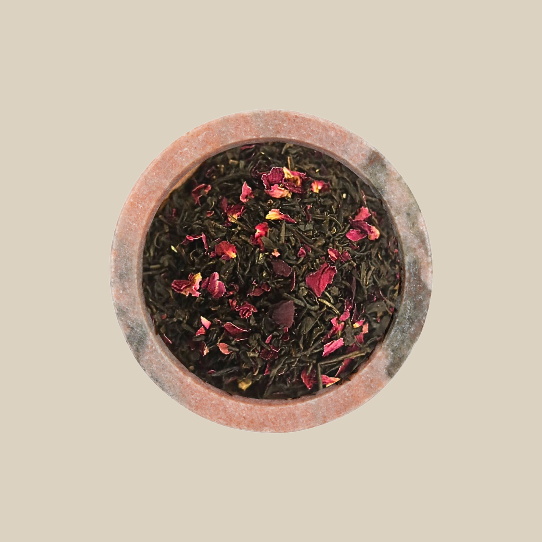 Gypsy Caravan, smoky black tea scattered with pink rose petals in a stone bowl